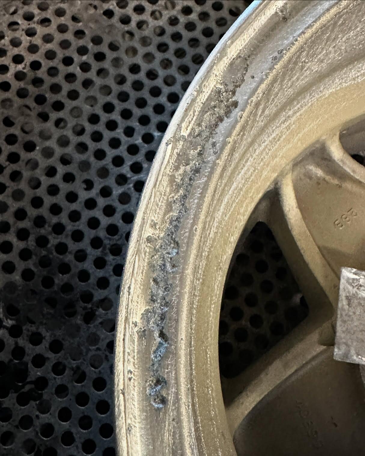 Alloy wheel corrosion closeup showing damage from untreated kerb rash